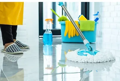 Cleaner using a microfiber cloth and organized supplies in a bright, well-maintained home